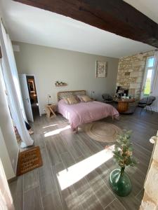 a bedroom with a bed and a vase on the floor at La Gouronerie in Parçay-sur-Vienne
