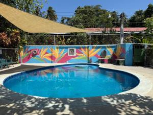 a swimming pool with a mural on a wall at Hostal Tia Reyna in El Zonte