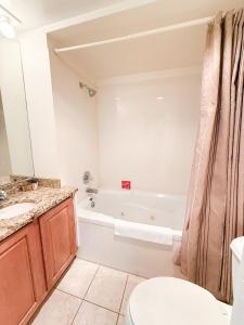 a bathroom with a toilet sink and a tub at Treetop Village-2bed2bathpoolsdockpickleball in Four Seasons