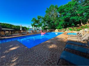 a swimming pool with chaises and chairs in a resort at Treetop Village-2Bed2BathPoolsDockPickleball in Four Seasons