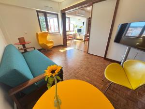 a living room with a couch and a table with a sunflower at Sesimbra Universal in Sesimbra