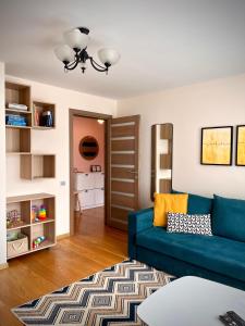 a living room with a blue couch and a rug at SUNSET Apartment Near Sea - Family Friendly space with Bath and Good Coffee in Ventspils