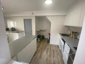 a kitchen with white cabinets and a wooden floor at Casa Rural Boni in Fuentemolinos