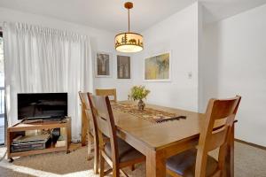 a dining room with a wooden table and a television at Double Eagle A12 by Ski Country Resorts in Breckenridge