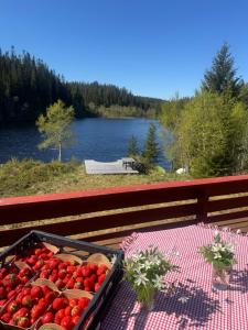 a tray of strawberries sitting on a table next to a picnic table at Lakeside cabin in Snofugl