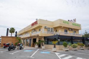 a hotel with motorcycles parked in a parking lot at Hotel Noguera El Albir in Albir