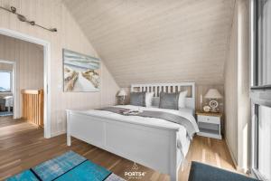 une chambre avec un grand lit blanc et du parquet dans l'établissement Ferienhaus Meerweh Olpenitz, à Olpenitz