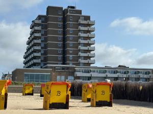 a row of yellow chairs in front of a building at Panorama Whg 25, 2 OG in Cuxhaven +14 photos