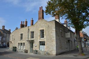 an old brick building with two chimneys on a street at The Crown in Woodstock