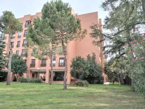 a large pink building with trees in front of it at Areropuerto Wanda en Plenilunio 3 3 B in Madrid