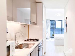 a kitchen with white cabinets and a sink at Luxury Living in Azizi Riviera l Cozy Balcony in Dubai
