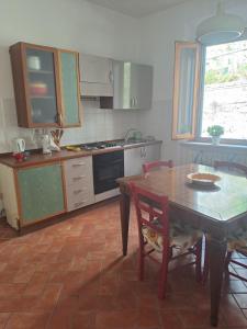 a kitchen with a table and a table and chairs at La casa nel castello in Rosignano Marittimo