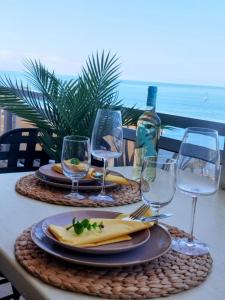 a table with two plates of food and wine glasses at Sol del Sur Ocean View in Puerto de Santiago