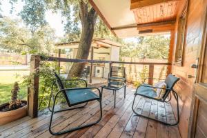 een veranda met drie stoelen en een boom bij Cabaña Rural El Arbol near Setenil - Ronda con piscina in Ronda