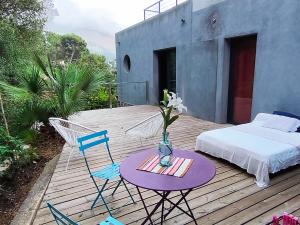a wooden deck with a bed and a table and chairs at BOUTIQUE HOSTEL BY Cassis in Cassis +37 photos