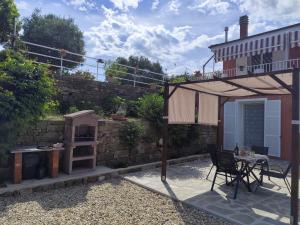 a patio with a table and an umbrella at La Casa di Giada, appartamento a piano terra con aria condizionata, wi-fi e parcheggio gratuito in Poggi