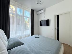 a bedroom with a bed and a large window at Delicious Aparts in Odesa