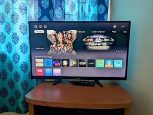 坎多林1 Bedroom apartment with Pool - Free Parking - Kitchen - Casa Stay的木桌旁的平面电视