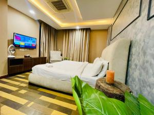 a hotel room with a bed and a tv at Luxurious One-Bedroom Gold Crest Apartment with Stunning Balcony Retreat DHA Lahore in Dargai