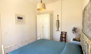 a bedroom with a bed with a blue bedspread at Nel cuore di Porto Azzurro - Goelba in Porto Azzurro +15 photos