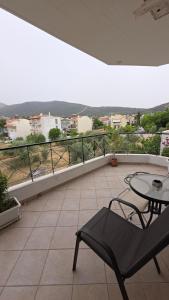 a balcony with a table and a chair and a view at Dimitris gerakas apartment in Mesochórion