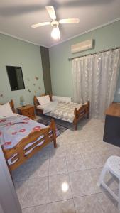 a bedroom with two beds and a ceiling fan at Dimitris gerakas apartment in Mesochórion