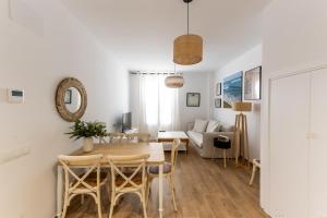 a dining room and living room with a table and chairs at Bodega Centro Olehousing in Conil de la Frontera
