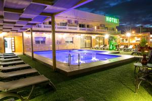 a pool at a hotel at night with tables and chairs at Hotel Noguera El Albir in Albir