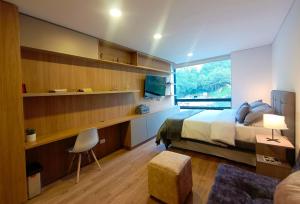 ボゴタにあるAH/ Loft vista Natural, Wifi 350 Mg, Bogotá Norteのベッドと机と窓のある寝室