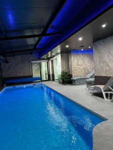 a swimming pool in a building with a blue ceiling at J&M Apartman Zlatibor in Zlatibor