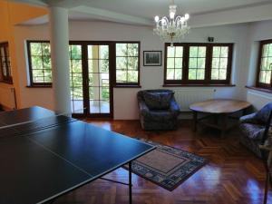 a living room with a table and chairs and windows at Casa de vacanță Tarnița in Someşu Cald