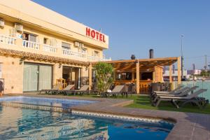 a hotel with a swimming pool in front of a building at Hotel Noguera El Albir in Albir