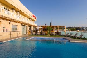 a swimming pool in front of a hotel at Hotel Noguera El Albir in Albir