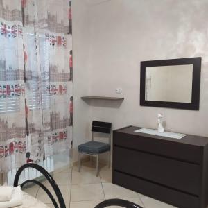 ポルト・チェザーレオにあるCasa Antonellaの鏡付きドレッサーと椅子が備わる客室です。