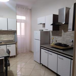 ポルト・チェザーレオにあるCasa Antonellaのキッチン(白いキャビネット、白い電化製品付)