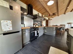 eine große Küche mit Küchengeräten aus Edelstahl und einem Tisch in der Unterkunft Maison 4 pièces avec parking et terrasse à Saint Georges d'Oléron - FR-1-246A-355 in Saint-Georges-dʼOléron + 9 Fotos