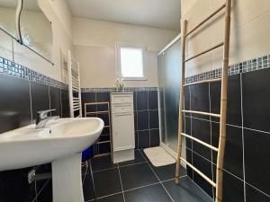 ein Badezimmer mit einem weißen Waschbecken und einer Dusche in der Unterkunft Maison 4 pièces avec parking et terrasse à Saint Georges d'Oléron - FR-1-246A-355 in Saint-Georges-dʼOléron