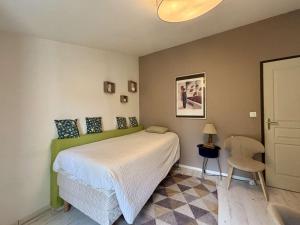 ein Schlafzimmer mit einem Bett und einem Stuhl in der Unterkunft Maison 4 pièces avec parking et terrasse à Saint Georges d'Oléron - FR-1-246A-355 in Saint-Georges-dʼOléron