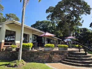 a building with tables and chairs and umbrellas at Villa T7 - Selborne Golf Estate in Pennington