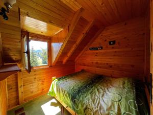 a bedroom in a log cabin with a bed in it at Guest House Milena in Žabljak