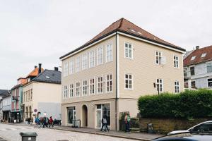 ベルゲンにあるDINBNB Apartments l 200m to Bryggen l Luxury 2 BR l 2min to Floibanenの通りを歩く人々のいる道路の建物