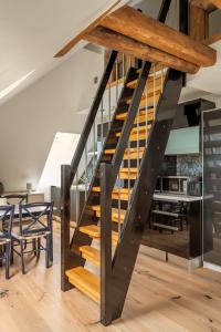 a staircase in a loft with a table and chairs at DINBNB Apartments l 200m to Bryggen l Luxury 2 BR l 2min to Floibanen in Bergen
