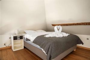 ベルゲンにあるDINBNB Apartments l 200m to Bryggen l Luxury 2 BR l 2min to Floibanenのタオルが敷かれたベッドのある寝室