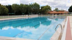 a large swimming pool with blue water at Casa Rural El Montaraz de Gema in Gema