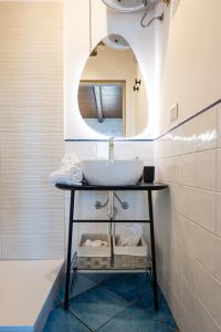 een badkamer met een wastafel en een spiegel bij CefalHome - TORRE in Cefalù