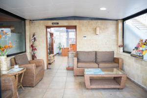 a waiting room with couches and chairs and a table at Hotel Noguera El Albir in Albir
