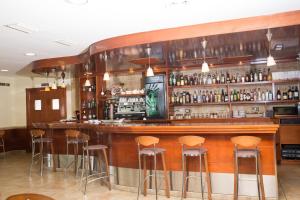 a bar with stools in a room with alcohol at Hotel Noguera El Albir in Albir