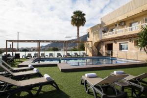a resort with a swimming pool and lounge chairs at Hotel Noguera El Albir in Albir