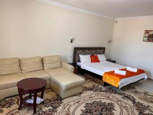 a living room with a couch and a bed at Avlod Guest House in Samarkand