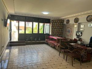 a bedroom with two beds and a table and chairs at Avlod Guest House in Samarkand